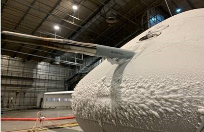 Protector aircraft being tested in a cold environment within a hangar. Ice forms on its outside.